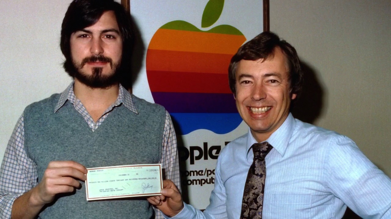 Steve Jobs and Mike Markkula with a cheque symbolising his investment in Apple, 1977