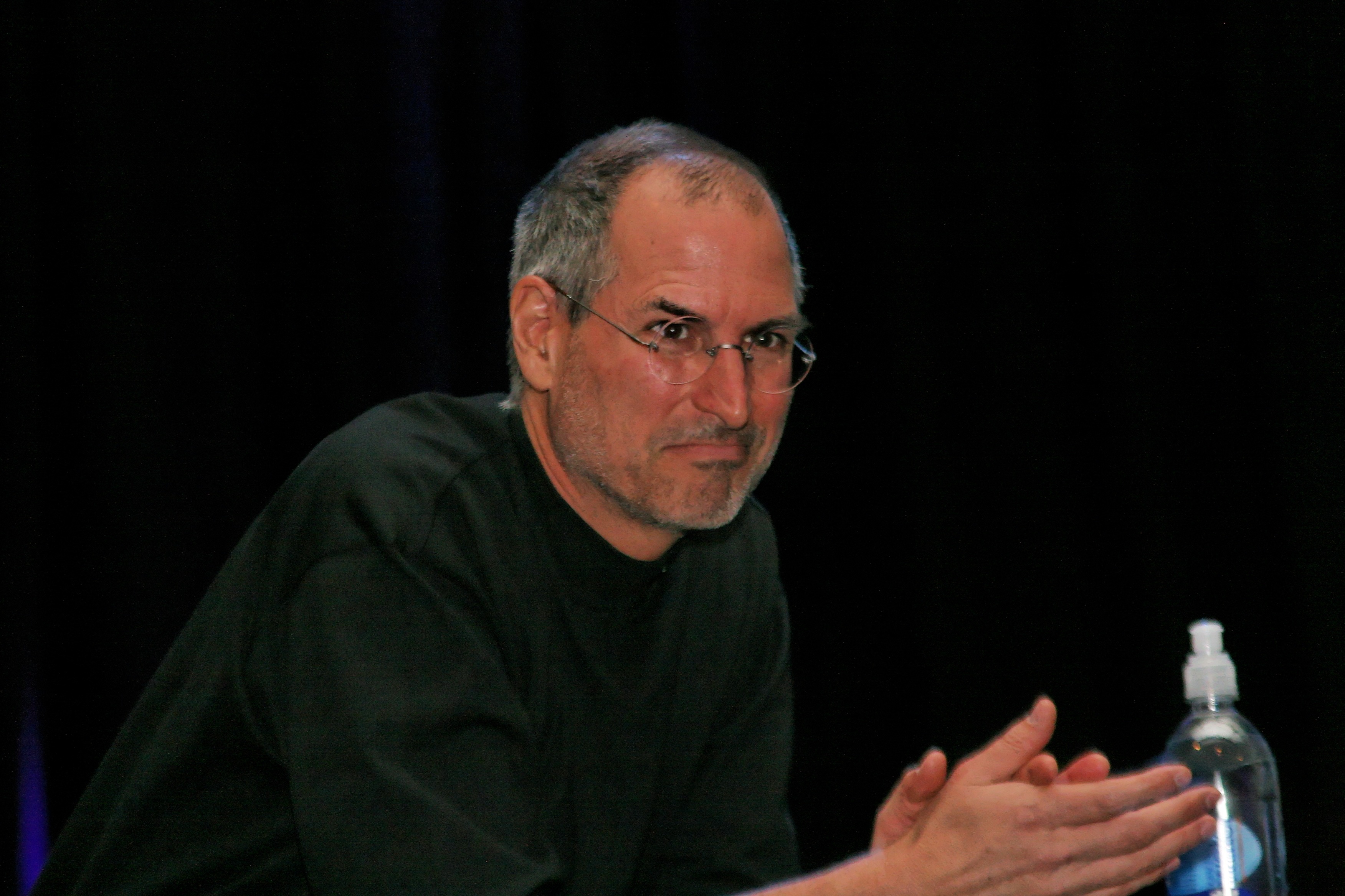 Steve Jobs watches as he hands over the stage