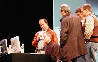 Steve Jobs working on his keynote slides. Avie Tevanian can be seen on the right (behind the two men)